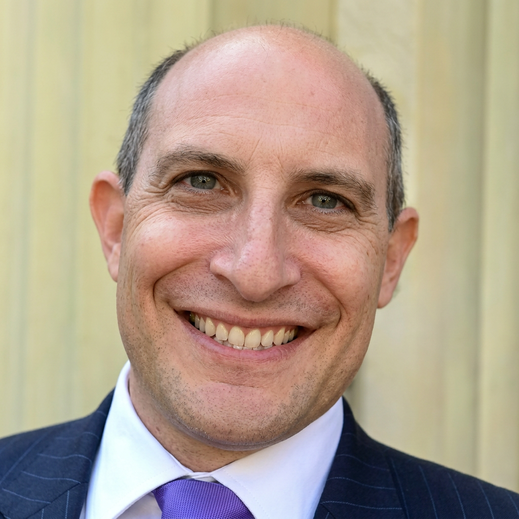 Portrait of Justin Taylor, founder of SaaSMarketing.co.uk, smiling in a suit